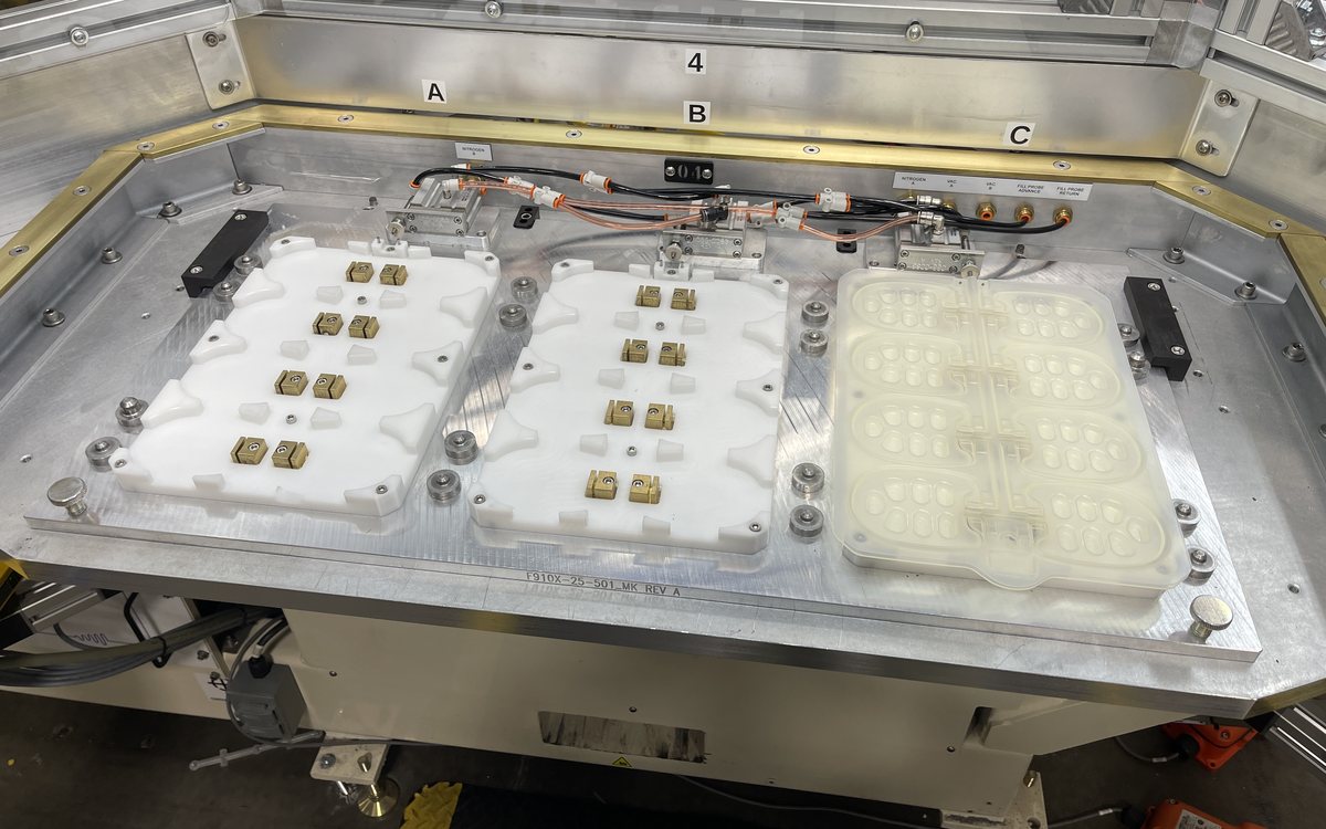 Trimming fixture holding formed trays on a machine bed